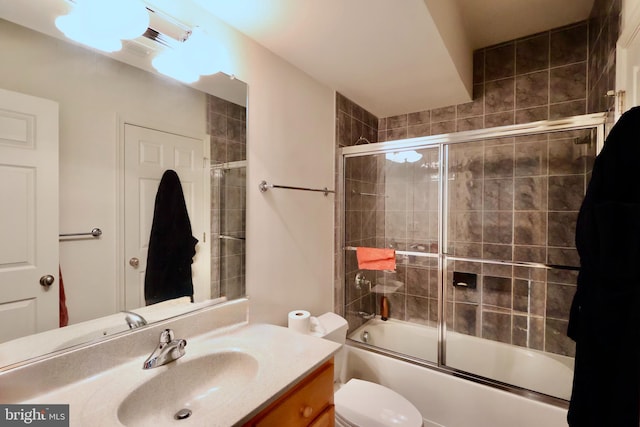 full bath featuring vanity, toilet, and combined bath / shower with glass door