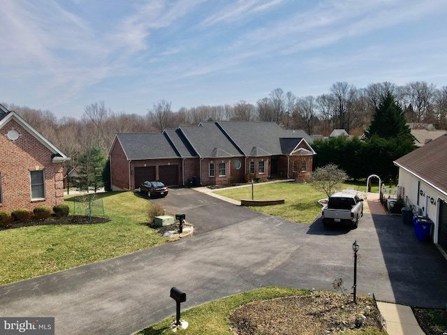 view of front facade with aphalt driveway, an attached garage, and a front yard