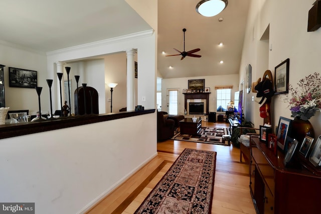 interior space featuring high vaulted ceiling, decorative columns, recessed lighting, ornamental molding, and light wood-type flooring