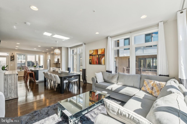 living area with dark wood-type flooring and recessed lighting