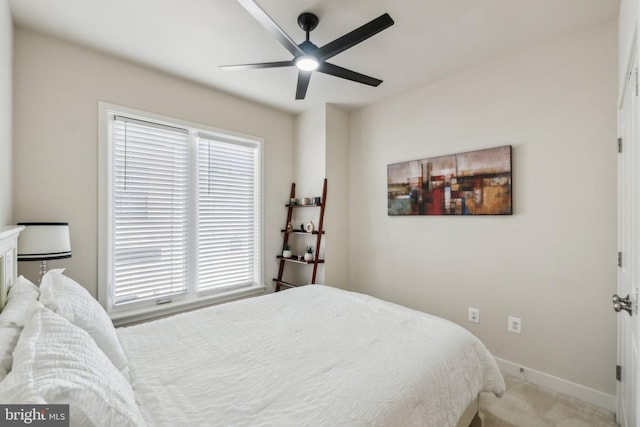 bedroom featuring baseboards, light carpet, and a ceiling fan