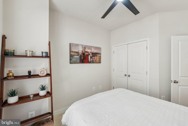 carpeted bedroom with a closet, baseboards, and a ceiling fan