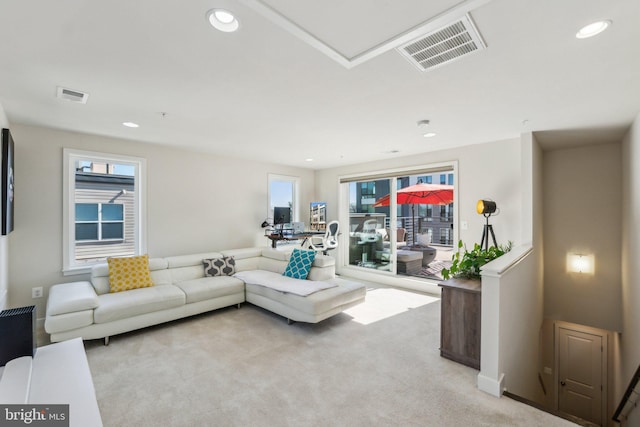 living area featuring recessed lighting, light colored carpet, and visible vents