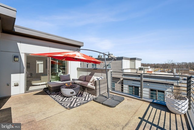 view of patio / terrace with an outdoor living space with a fire pit and a balcony