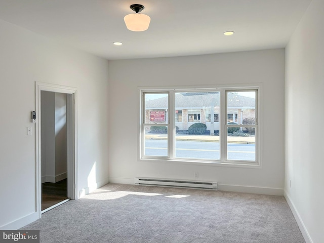 spare room with a baseboard heating unit, recessed lighting, carpet floors, and baseboards