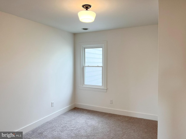 spare room featuring visible vents, baseboards, and light colored carpet