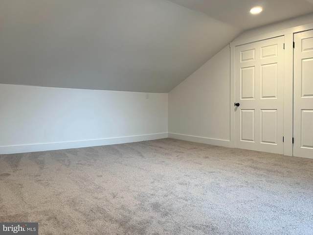 additional living space with vaulted ceiling, carpet flooring, and baseboards