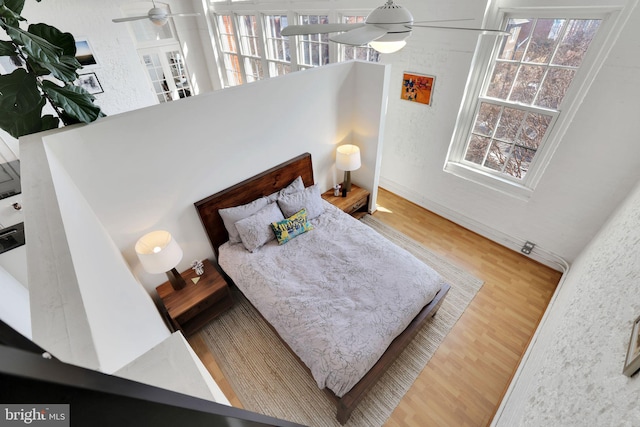 bedroom with wood finished floors and a textured wall