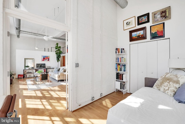 bedroom featuring a high ceiling and wood finished floors