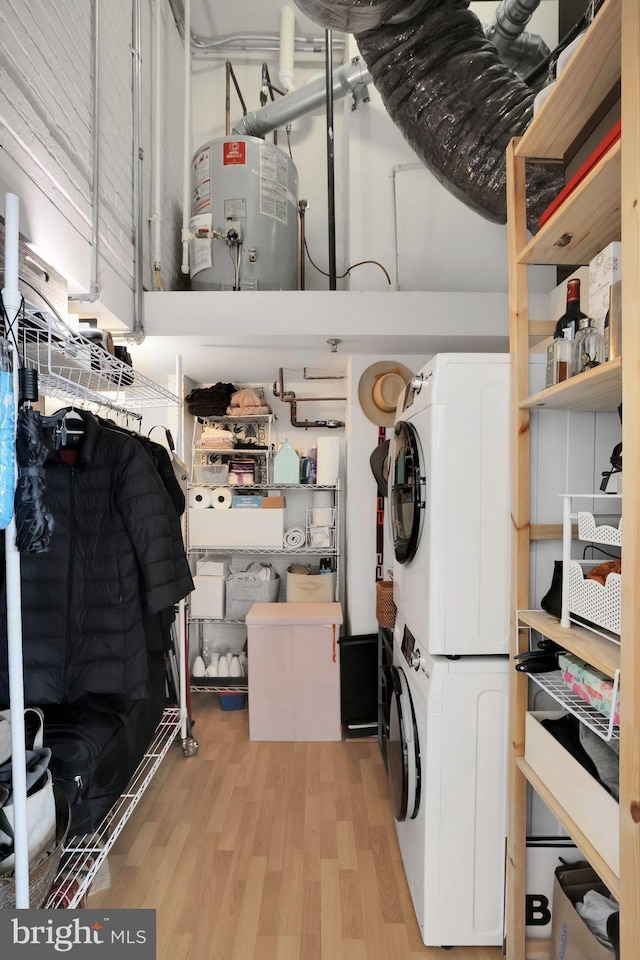 storage featuring water heater and stacked washer / drying machine