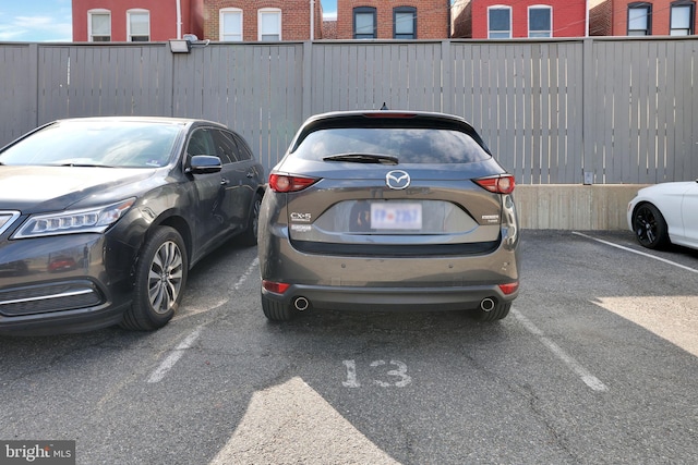 uncovered parking lot featuring fence