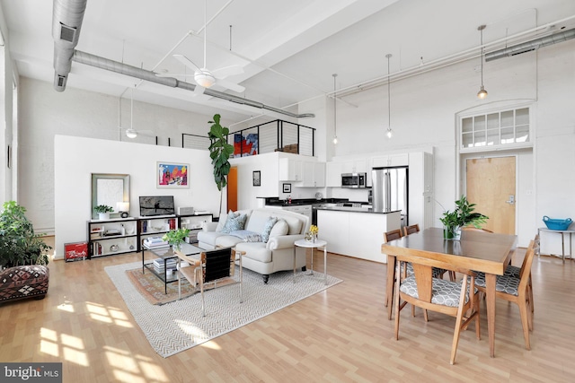 living area featuring a high ceiling and light wood-style floors