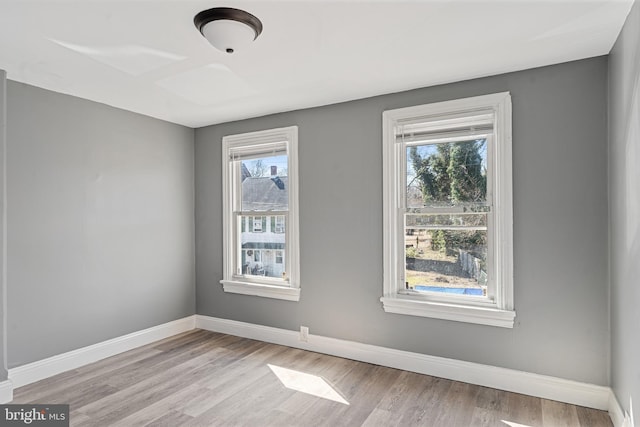 unfurnished room featuring baseboards and wood finished floors