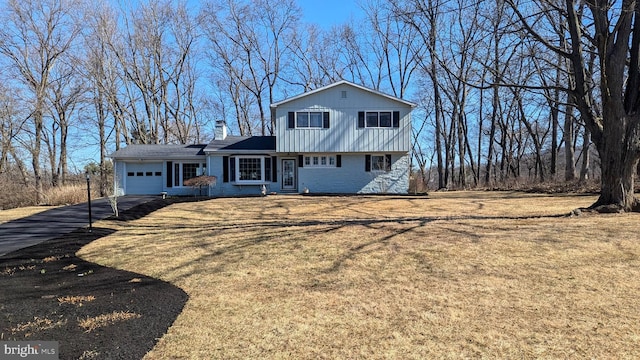 view of front facade featuring brick siding, board and batten siding, aphalt driveway, a front yard, and a garage