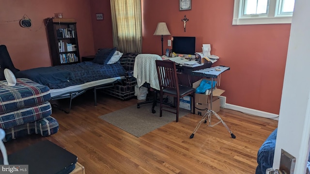 bedroom featuring baseboards and wood finished floors