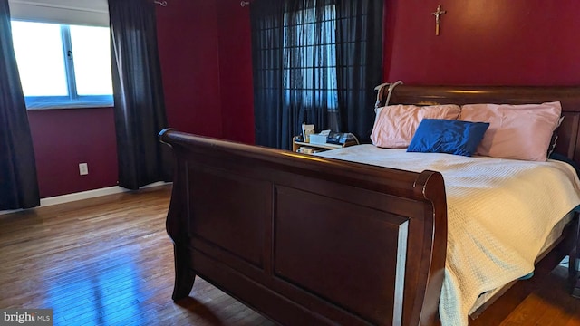 bedroom with wood finished floors and baseboards