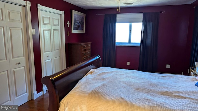 bedroom featuring visible vents, a closet, and wood finished floors