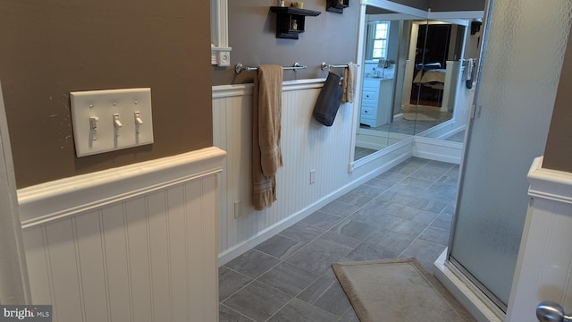 full bath with a shower and a wainscoted wall