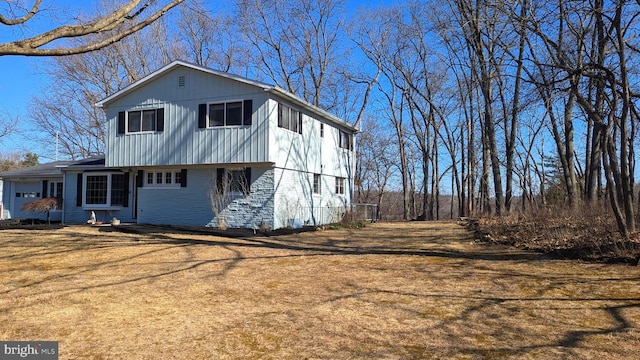 view of side of home featuring a lawn and brick siding