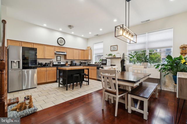 dining area featuring a healthy amount of sunlight, visible vents, and light wood finished floors