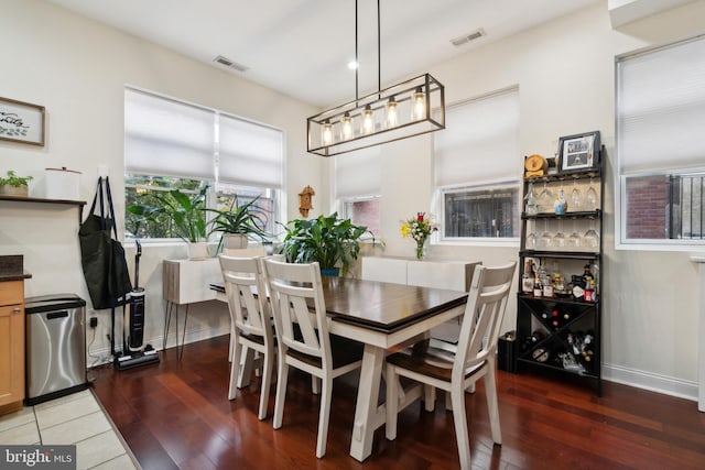 dining area with baseboards, visible vents, and hardwood / wood-style floors