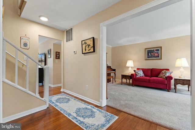 entrance foyer with wood finished floors, visible vents, baseboards, stairs, and ornamental molding