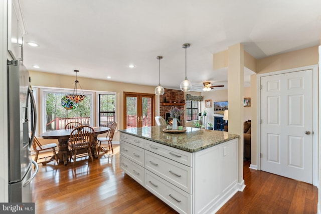 kitchen with white cabinets, stainless steel refrigerator with ice dispenser, and wood finished floors