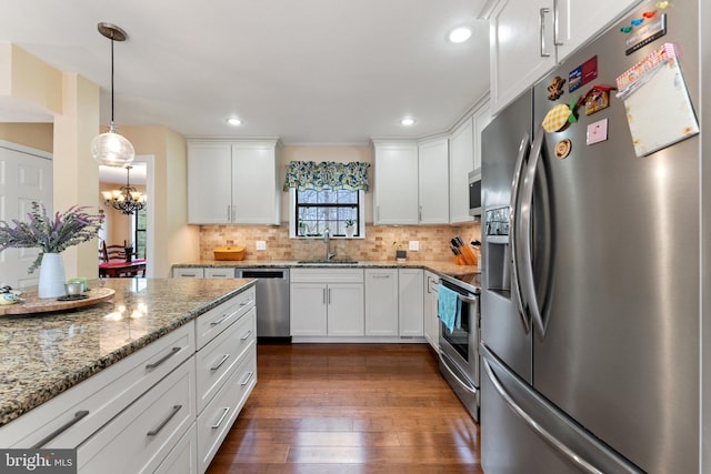 kitchen with dark wood-style flooring, tasteful backsplash, appliances with stainless steel finishes, white cabinets, and a sink