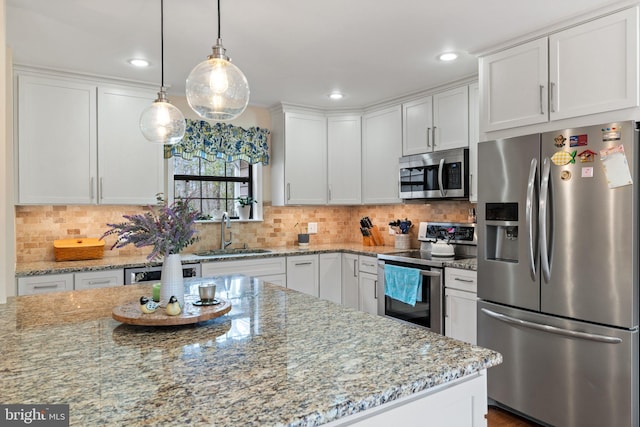 kitchen featuring appliances with stainless steel finishes, backsplash, a sink, and white cabinets