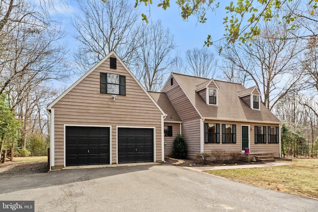 cape cod home with driveway, roof with shingles, a garage, and entry steps