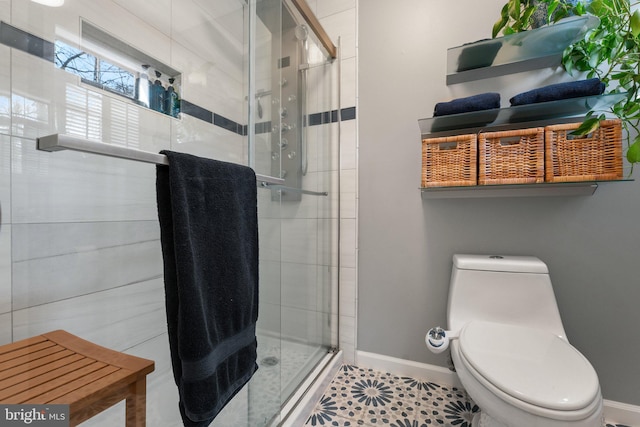 full bath featuring a stall shower, toilet, and baseboards