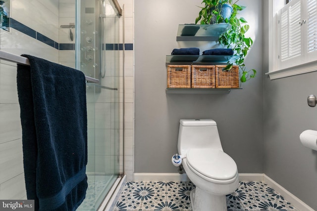 full bathroom featuring toilet, a stall shower, tile patterned flooring, and baseboards