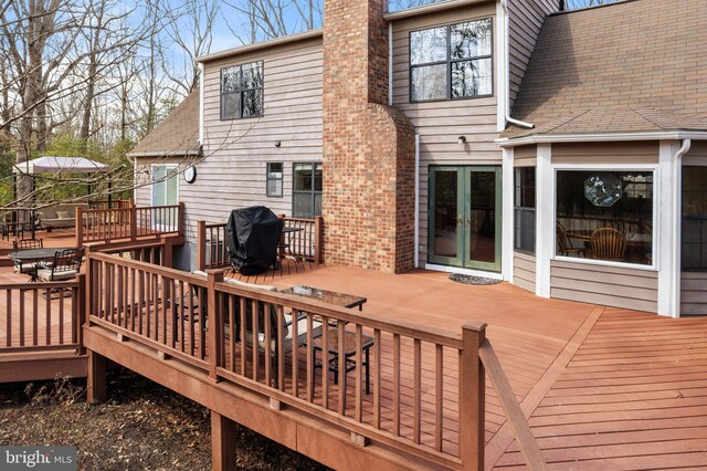 wooden terrace featuring french doors and area for grilling