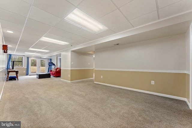 interior space featuring carpet floors, french doors, a paneled ceiling, and baseboards