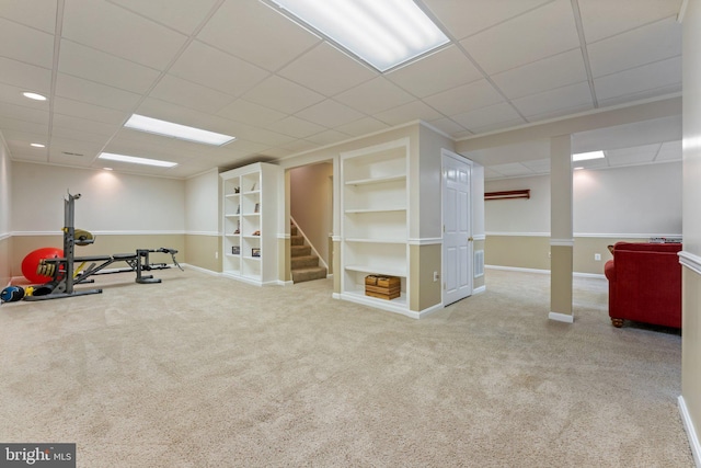 interior space with baseboards, built in features, a paneled ceiling, stairway, and carpet floors