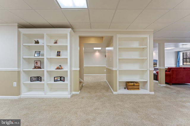 interior space featuring built in shelves, carpet flooring, and baseboards