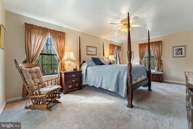 bedroom featuring ceiling fan, multiple windows, carpet flooring, and baseboards