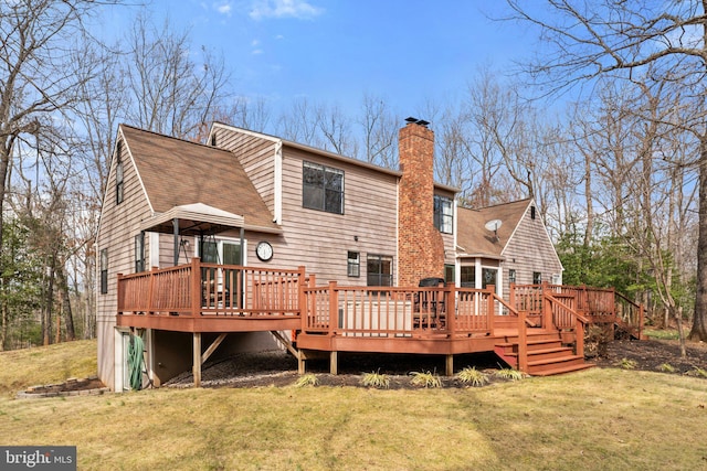 back of property with a chimney, a deck, a lawn, and roof with shingles