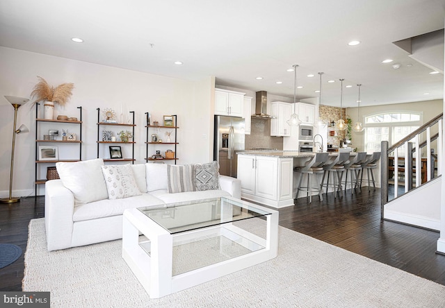 living room with recessed lighting, dark wood finished floors, stairway, and baseboards