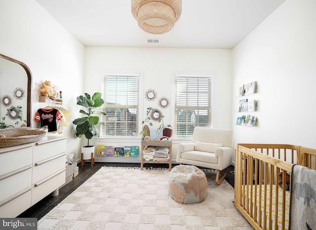 bedroom featuring a nursery area and visible vents