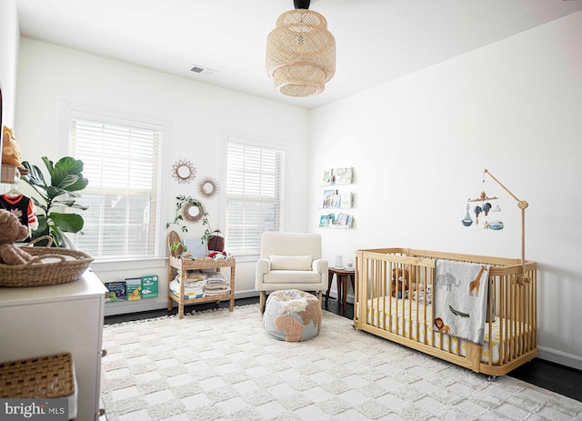 bedroom featuring a nursery area and visible vents