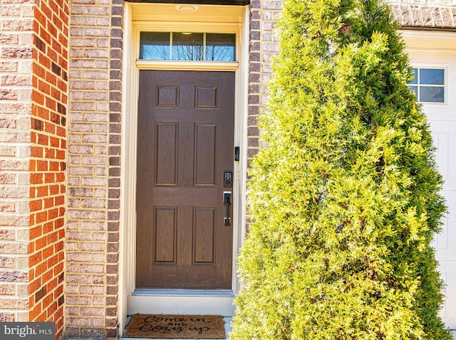 doorway to property featuring brick siding