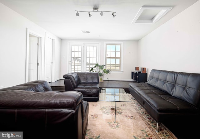 living room featuring attic access, track lighting, visible vents, and baseboards