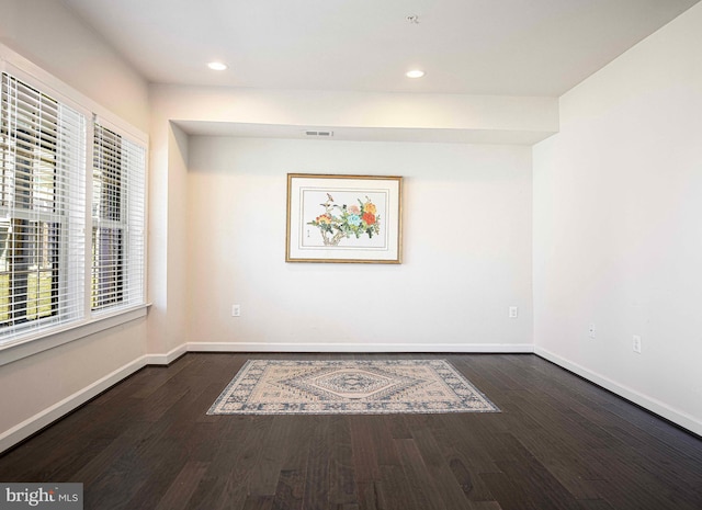 unfurnished room featuring recessed lighting, wood finished floors, visible vents, and baseboards