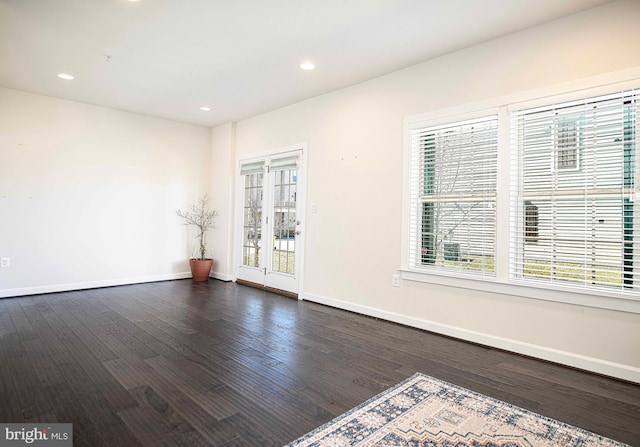 empty room with dark wood-style flooring, recessed lighting, and baseboards