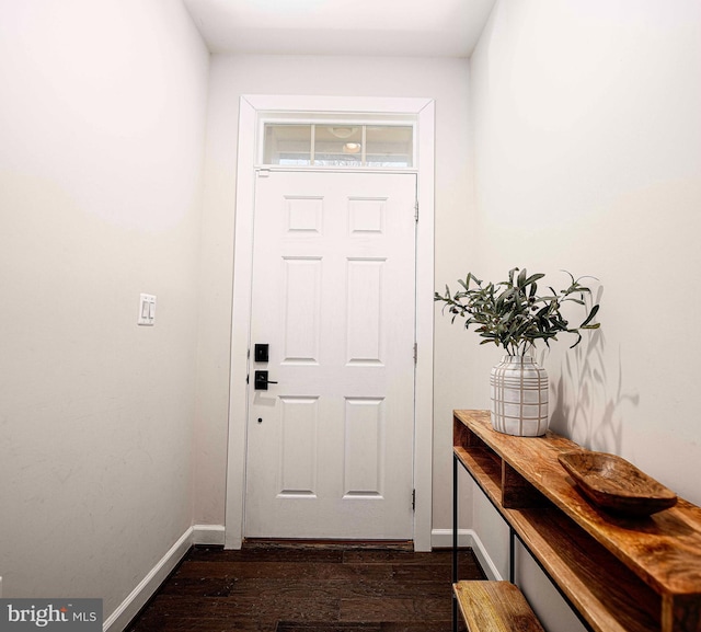 doorway with dark wood-style floors and baseboards