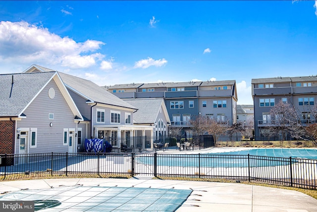 pool featuring a patio area, fence, and a residential view