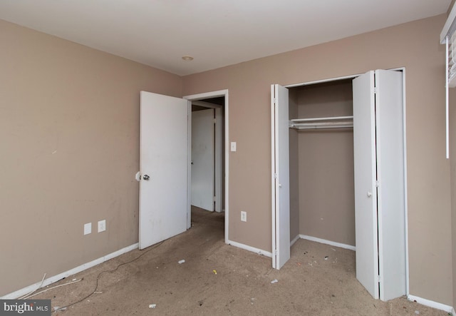 unfurnished bedroom with a closet and baseboards