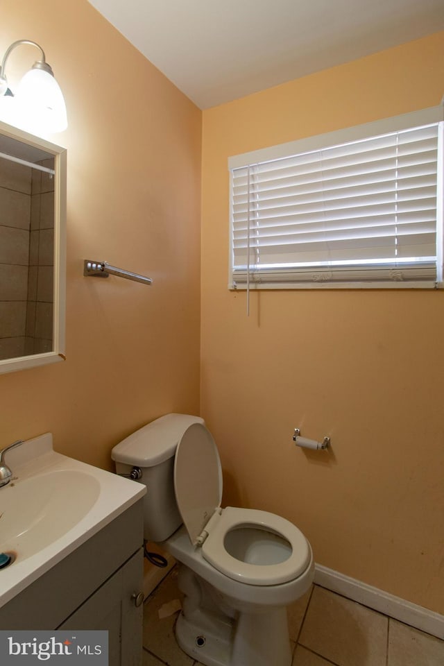 bathroom with tile patterned flooring, toilet, vanity, and baseboards