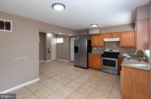 kitchen with tasteful backsplash, visible vents, under cabinet range hood, appliances with stainless steel finishes, and a sink